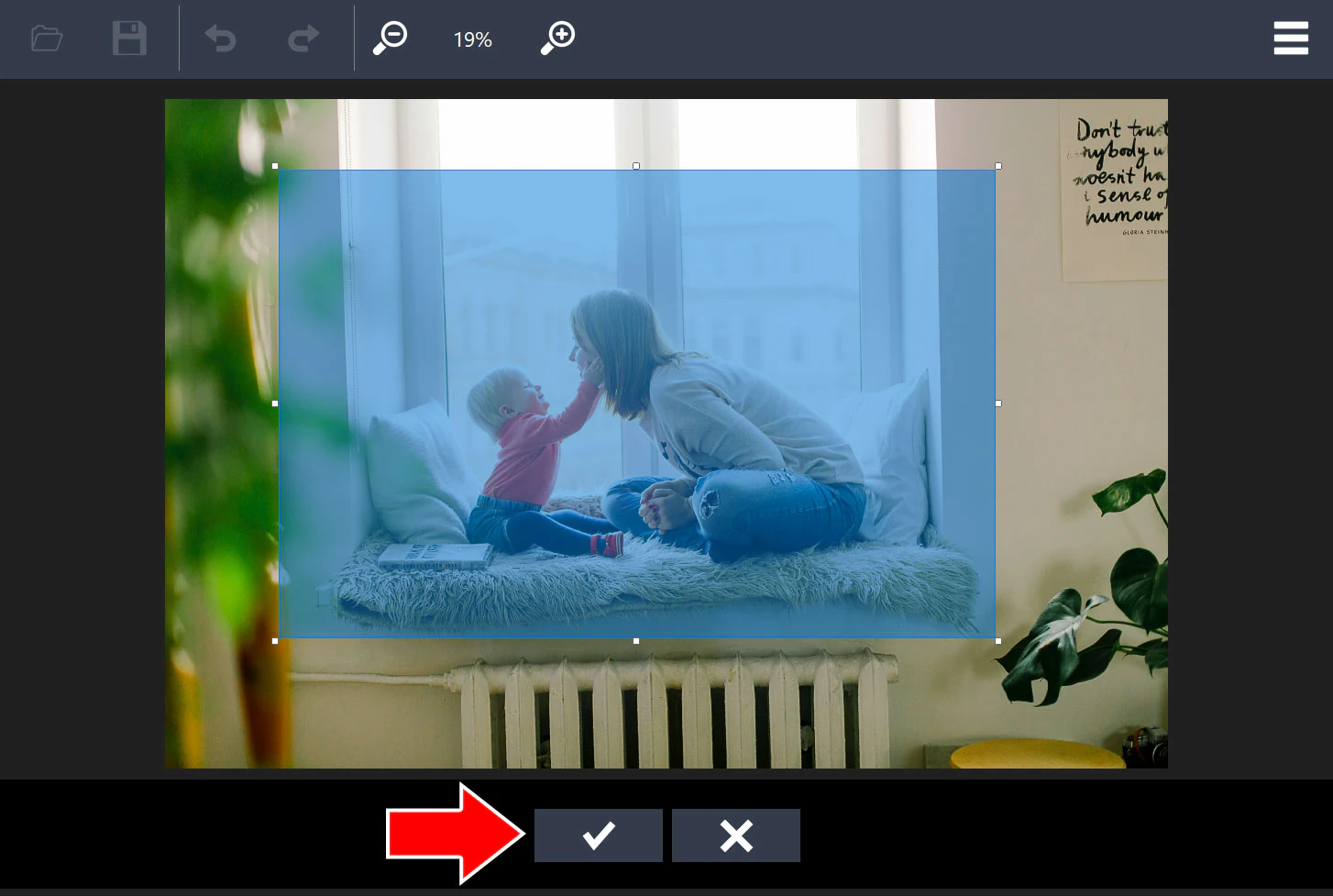 Highlighted crop area with handles on the photo and an arrow pointing to the check mark button